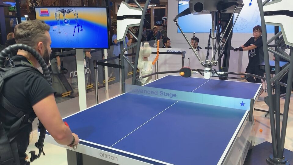 Eric Matzner playing table tennis against a robot at CES